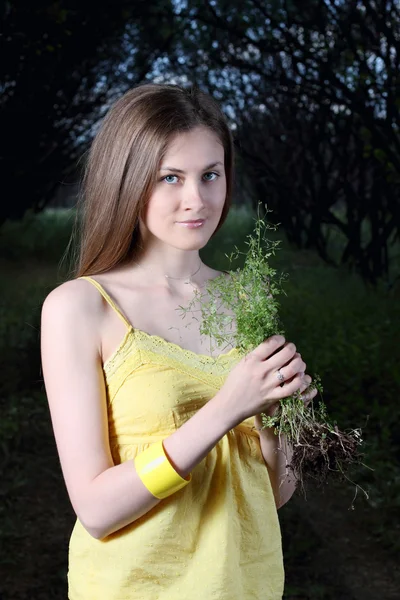 Roztomilá dívka drží chomáč trávy — Stock fotografie