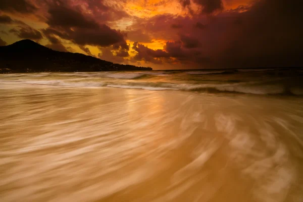 Colorido atardecer con cielo tormentoso y playa dorada —  Fotos de Stock