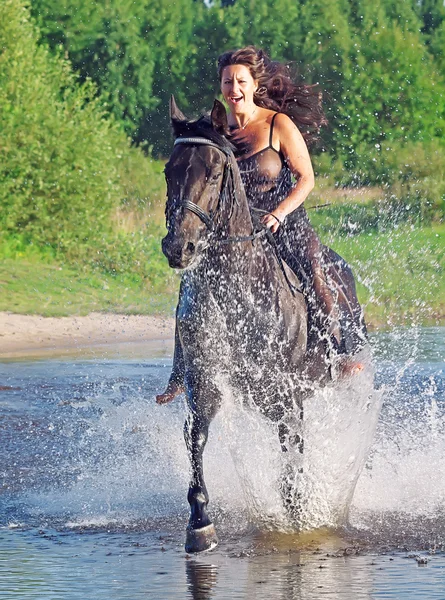 Sexy vrouwen galopperen op paard bij lake — Stockfoto