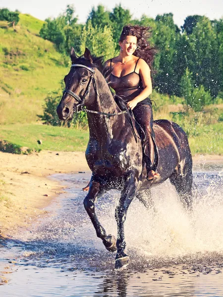 Sexy vrouwen galopperen op paard bij lake — Stockfoto