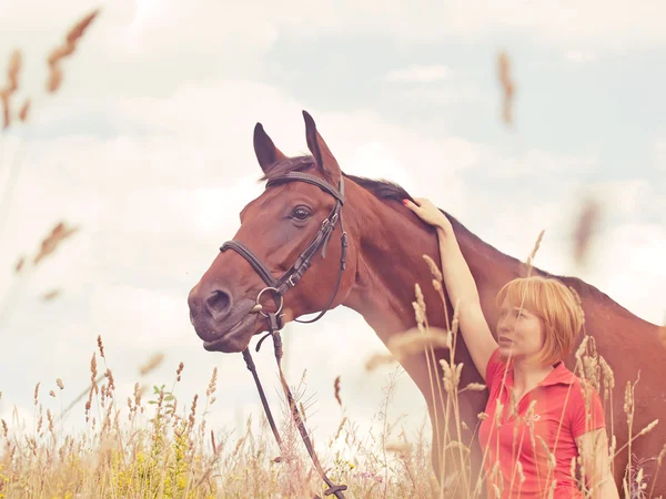 Vrij jong meisje met de jouwe paard in bewolkte dag — Stockfoto