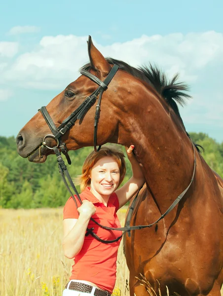 Krásná mladá dívka s tvůj kůň v poli — Stock fotografie