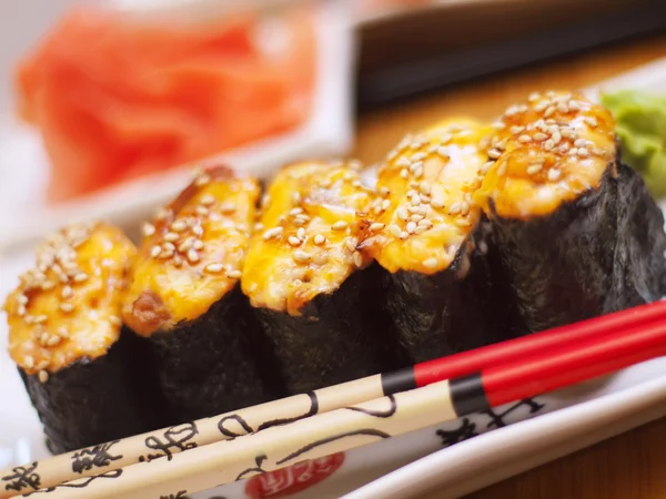 Hot sushi on plate with chopsticks — Stock Photo, Image