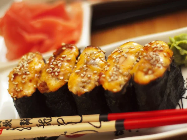 Sushi caldo su piatto con bacchette — Foto Stock