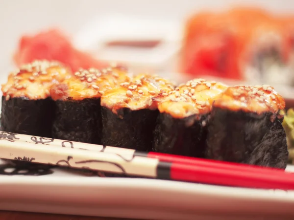 Sushi chaud sur assiette avec baguettes — Photo