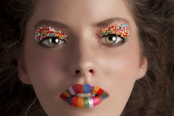 一个年轻的女孩穿着糖果的脸拍组成 — 图库照片