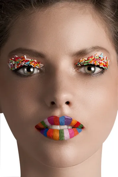 Zoom sur un visage de fille avec lèvres arc-en-ciel et paupières de bonbons — Photo
