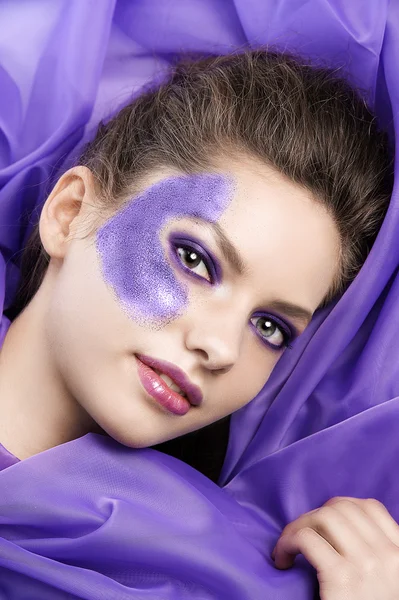 Układanie modelu na purpurowe tkaniny — Zdjęcie stockowe