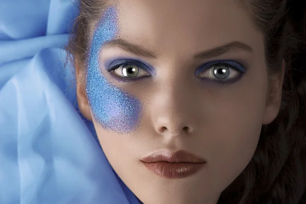 Gezicht shot van een legdatum model met blauwe glitter make-up — Stockfoto