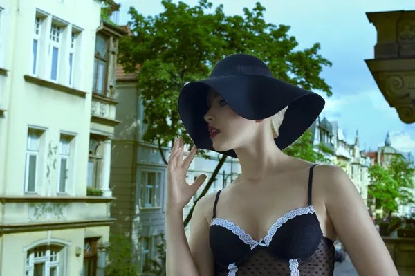 Mode skott med vacker kvinna som bär en hatt i gamla stads bac — Stockfoto