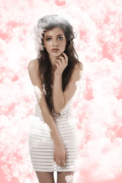 Model giyen beyaz elbise ve beyaz yumuşak pembe featheron poz — Stok fotoğraf