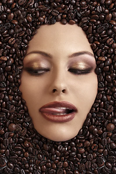 stock image Close up portrait of a girl's face immersed in coffee beans