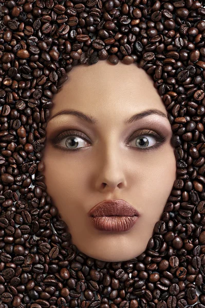 Portrait of a pretty girl laying among coffee beans — Stock Photo, Image