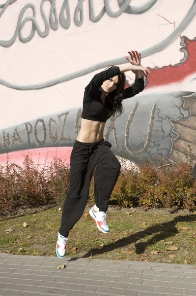 Современная танцовщица рядом с граффити — стоковое фото