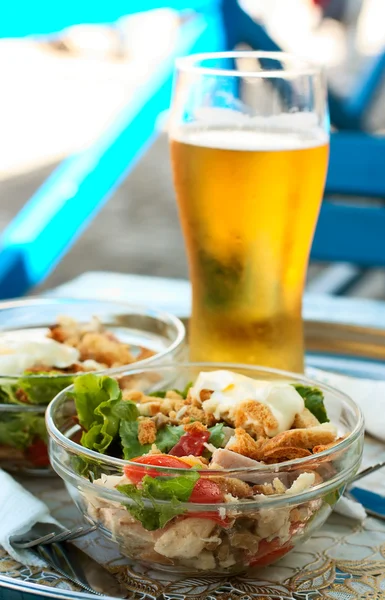 Salad of meet, crackers and vegetables and glass of beer — Stock Photo, Image