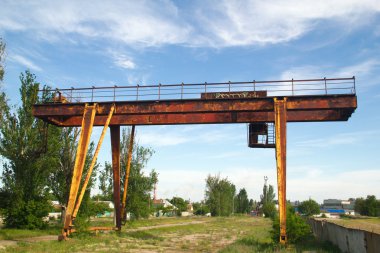 Abandoned gantry crane on a background of blue sky clipart