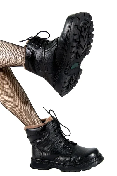 Mooie vrouwen voeten in schoenen van de mannen, geïsoleerd op een witte bac — Stockfoto