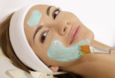 Young woman getting beauty skin mask treatment on her face with clipart
