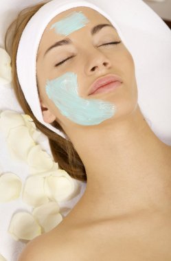 Young woman getting beauty skin mask treatment on her face with clipart