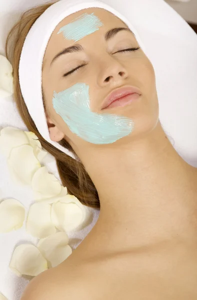 Ung kvinna att få skönhet hud mask behandling på hennes ansikte med — Stockfoto