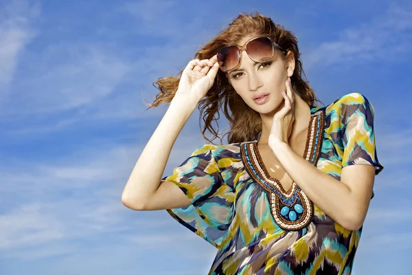 Красива дівчина в сонцезахисних окулярах на фоні блакитного неба — стокове фото
