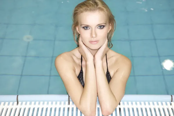 Hermosa joven de pie en una piscina — Foto de Stock