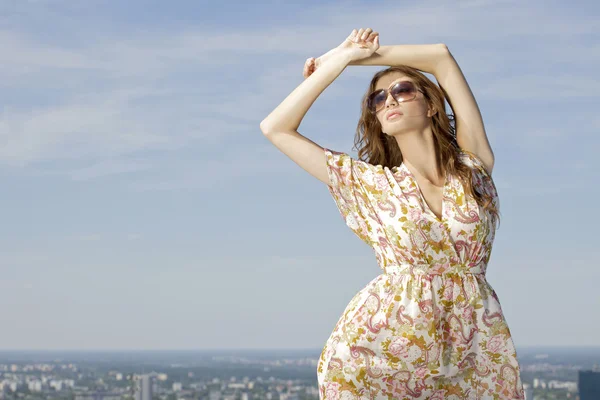 Красивая девушка в солнечных очках на фоне голубого неба — стоковое фото