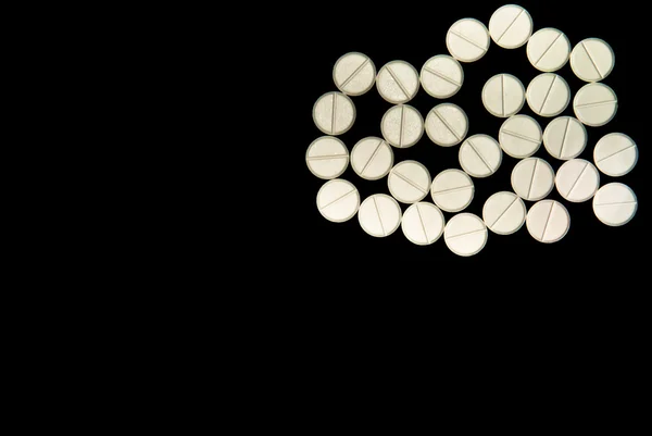 Pillole bianche su sfondo nero — Foto Stock
