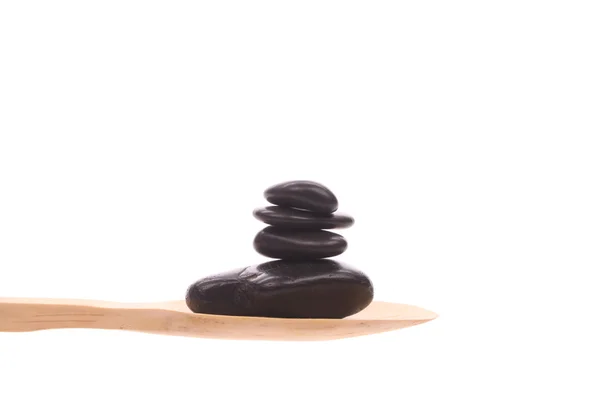 Massage-stenen op een houten lepel geïsoleerd op een witte achtergrond — Stockfoto