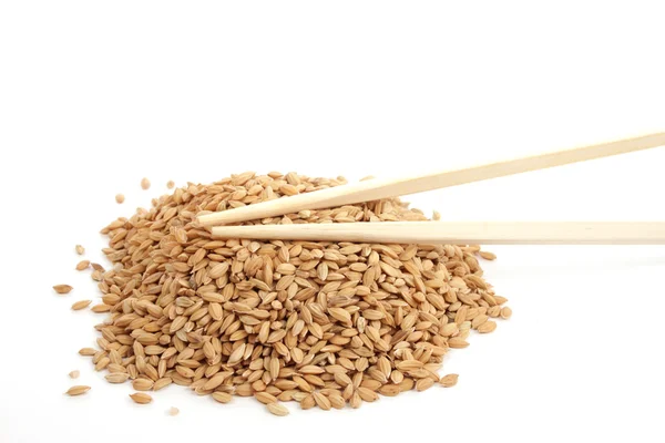 Unpeeld rice and chopsticks — Stock Photo, Image
