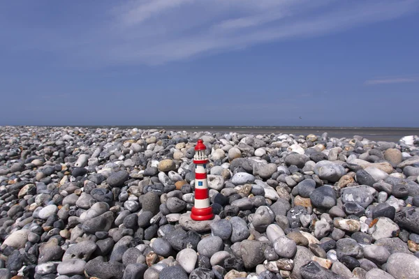 Klein model vuurtoren op flintstone langs de kust — Stockfoto