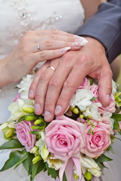 Bouquet de mariage et les mains avec des anneaux — Photo