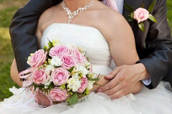 Bruiloft boeket en de bruidegom met de bruid — Stockfoto