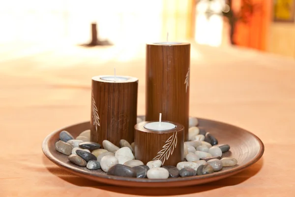 Kerzen in einem Holzbecher mit Steinen — Stockfoto