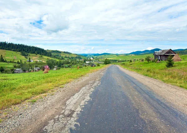 Sommaren mountain village och country road — Stockfoto
