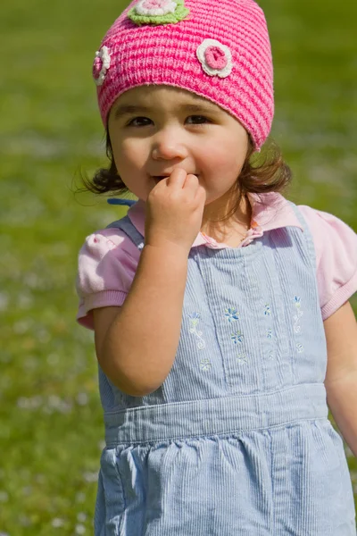 Toddler girl smiling in pink knit cap — Stock Photo, Image