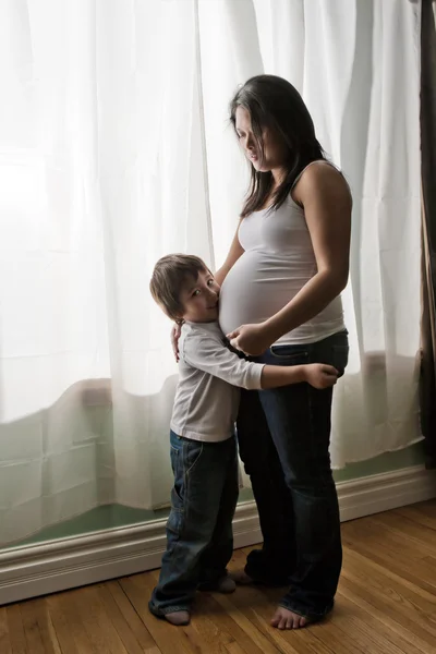 hamile genç Asyalı kadın ile oğlu kucaklama