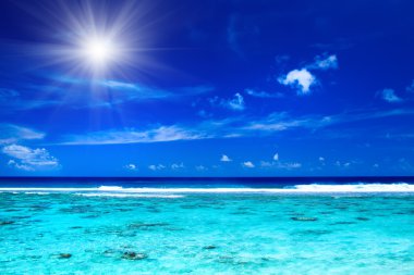 Sun over tropical ocean with vibrant colors clipart