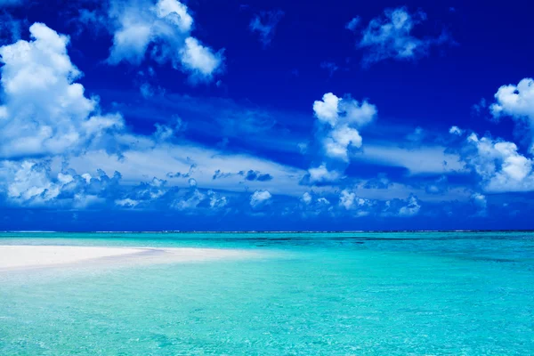 Mavi gökyüzü ve okyanus canlı renkleri ile plaj — Stok fotoğraf