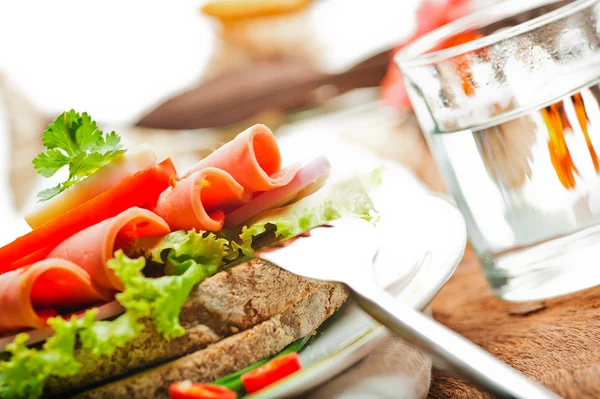 Kahverengi ekmek acılı sosis dilimleri ile yeşil salata domates ve yumurta — Stok fotoğraf