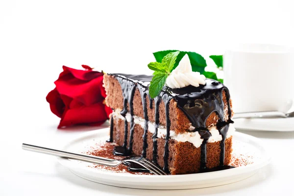 A piece of chocolate cake with vanilla cream and a rose — Stock Photo, Image