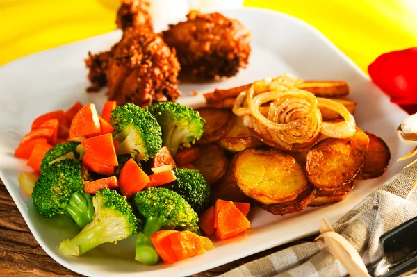 Fried potatoes broccoli carrots and roasted chicken — Stock Photo, Image