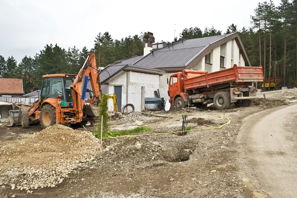 Excavadora en el sitio de trabajo, reparación de carreteras, casa de construcción — Foto de Stock