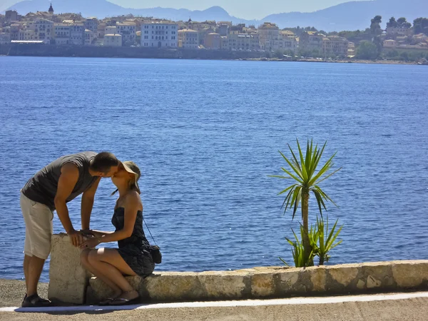 Jonge gelukkige paar kussen door de zee — Stockfoto