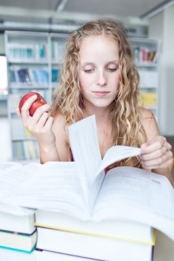 Güzel Bayan üniversite öğrencisi bir kitaplığı (sığ Dof; renk t