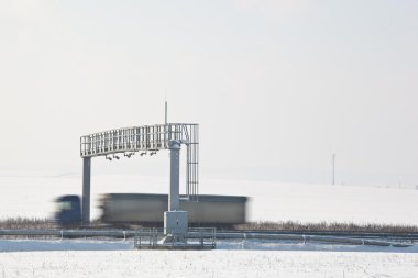 Truck passing trhough a toll gate on a highway (motion blurred i clipart