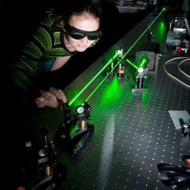 Kadın bilim adamı kuantum optik laboratuvarında araştırma yapıyor.