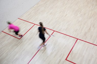 İki kadın squash oyuncular bir squash kortu (moti hızlı eylem içinde