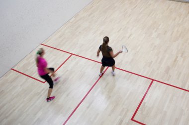 İki kadın squash oyuncular bir squash kortu (moti hızlı eylem içinde