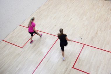 İki kadın squash oyuncular bir squash kortu (moti hızlı eylem içinde